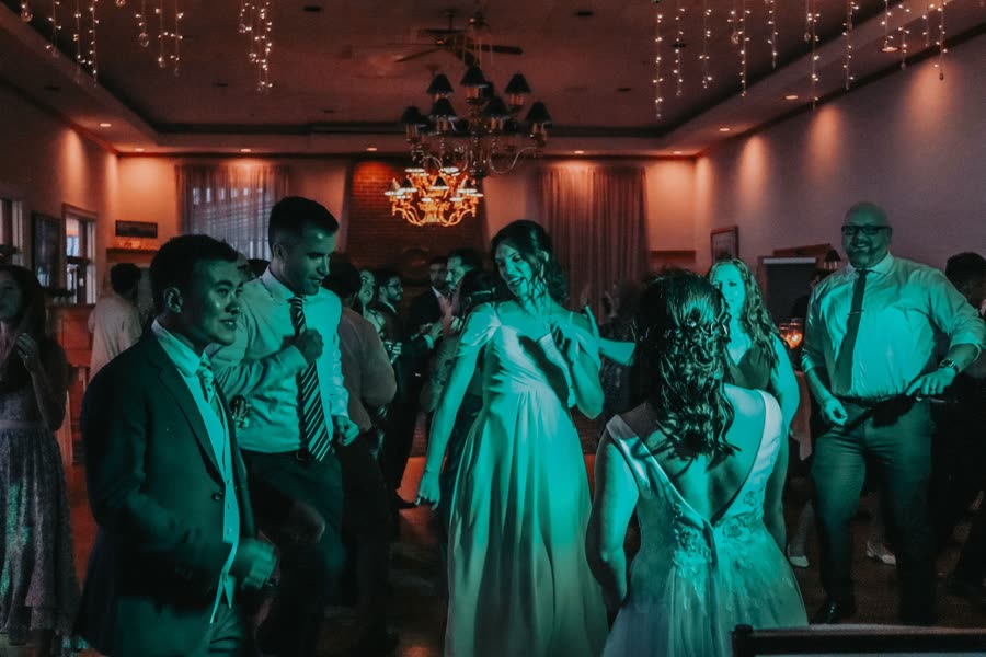 Bride dancing under a teal light wash