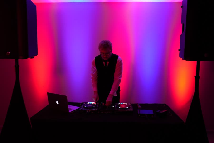 Joey at the Radiant Sound DJ booth, framed by red and blue uplighting